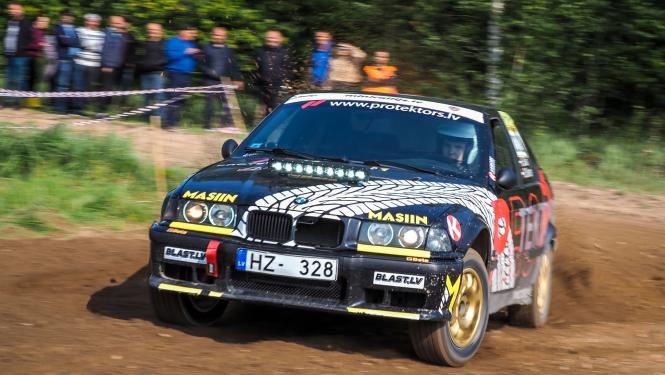 Sporta auto brauc aizmugurē skatītāji aiz norobežojuma piespiedu darbs