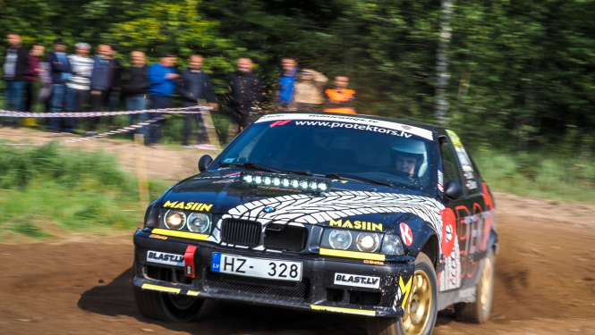 Sporta auto brauc aizmugurē skatītāji aiz norobežojuma piespiedu darbs