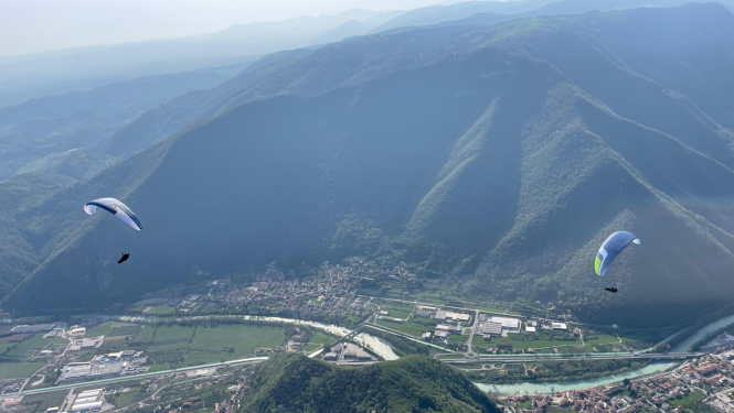 divi paraplāni lido virs ielejas starp kalniem