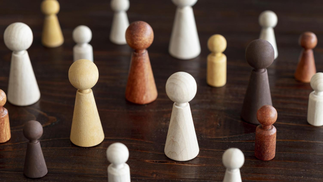 Dažādības vadība ziņas titulbilde. Dažādu krāsu un izmēru kauliņi uz galda.